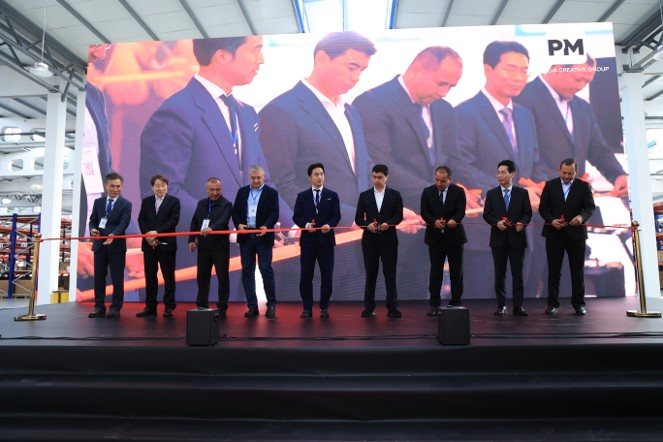 Ik Whan Kim (5th from the left), Vice Chairman of Hansae Mobility, Mirzoxid Murodilovich, Deputy Governor of Fergana Region, and other guests participate in a ribbon-cutting ceremony at the company's Turan plant in Uzbekistan on October 13, 2026.